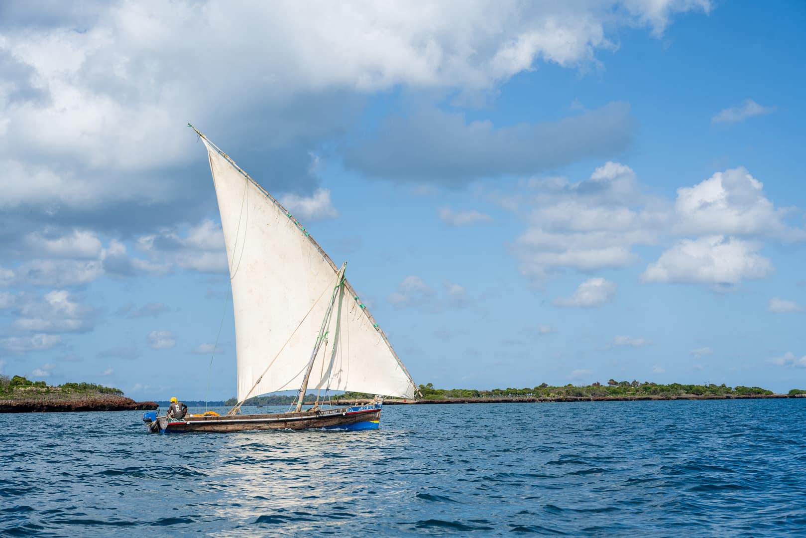 Ein traditionelles Dhow-Boot segelt auf dem Indischen Ozean, ein Highlight jeder Tansania und Sansibar Reise.