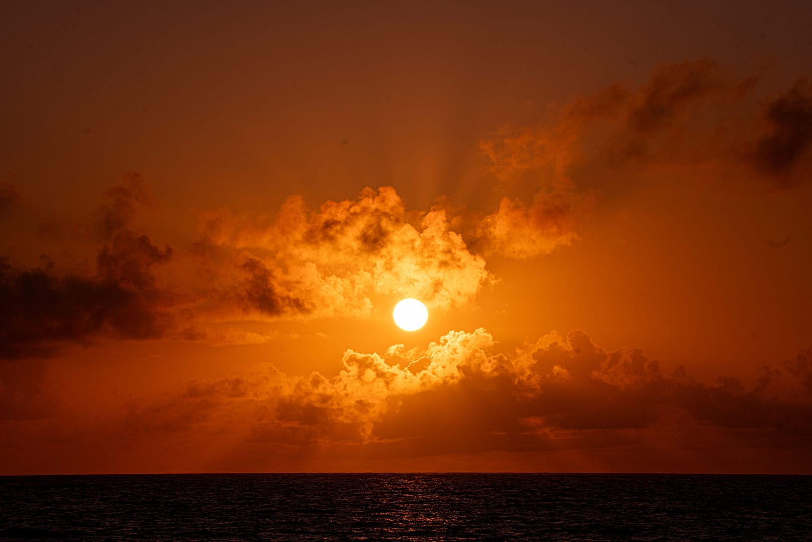 Ein feuriger Sonnenuntergang über dem Meer, ein unvergesslicher Anblick auf einer Privatsafari in Tansania.