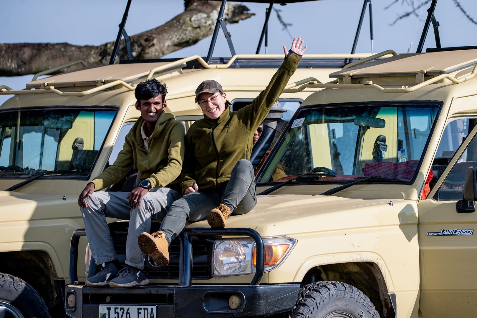 Zufriedene Gäste geniessen die Aussicht von unserem Safari-Fahrzeug während einer Luxus Safari in Tansania.
